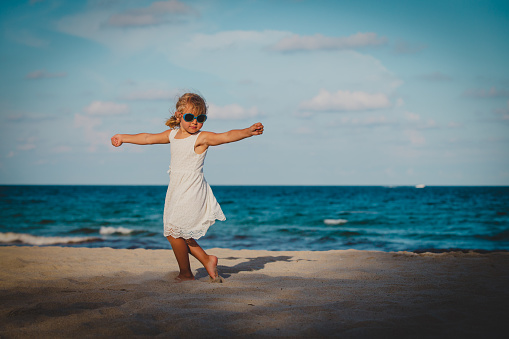 cute little girl dance play at summer tropical beach