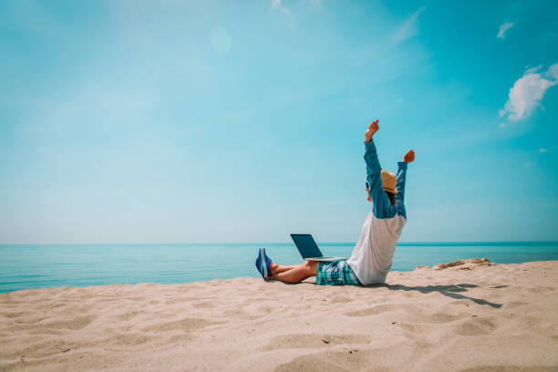 istock young man working on laptop at beach 1091676704