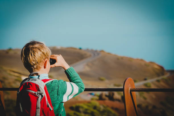 istock little boy looking through binocular hiking in mountains 1091676952