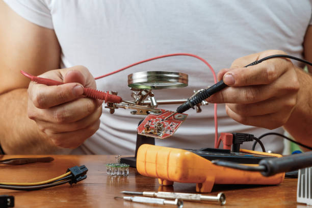 istock The man remotes the microcircuit. Workplace with soldering iron, microcircuit, magnifying glass, magnifying glass, measuring instruments. Electronics repair, master. 1091681088