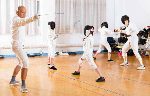 istock Coaches demonstrating to young athletes attack movements with rapier during fencing workout 1091688914