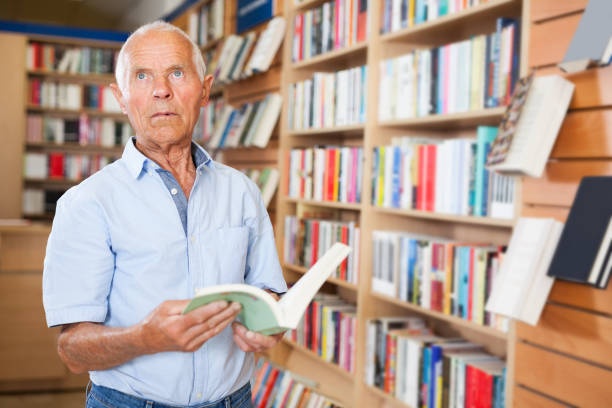istock Pensive senior man standing in library 1091690938
