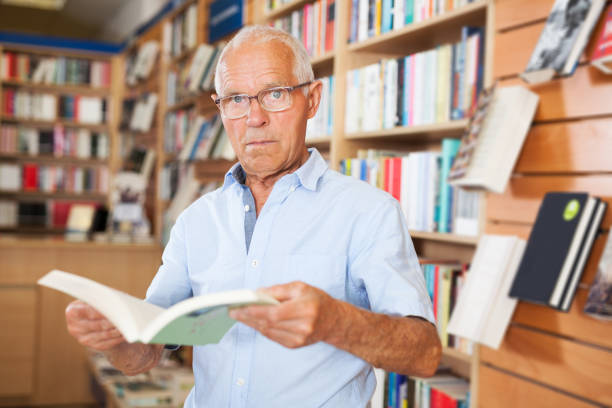 istock man absorbedly searching for interesting books 1091690964
