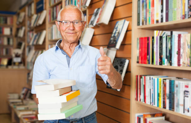 istock Elderly man holding books in bookstore 1091690976
