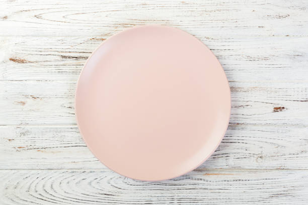 istock Directy above Empty rose matte plate on white wooden background 1091691226