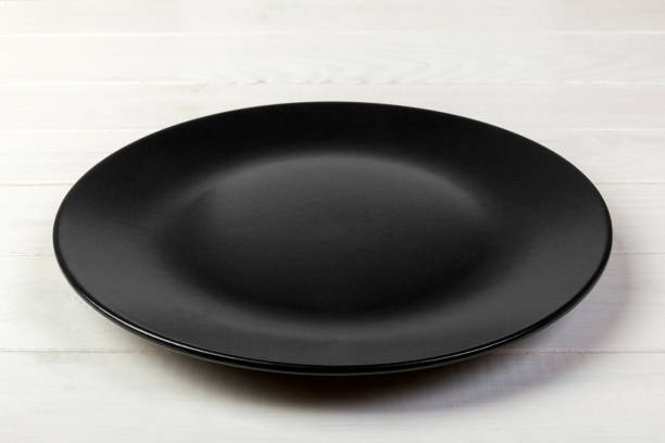 istock Perspective view. Empty dark matte dish for dinner on white wooden background 1091691258