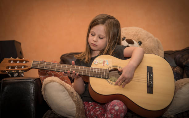 istock Young girl playing guitar at home 1091691640