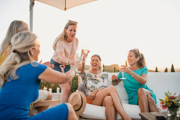 Women Toasting on Holiday Small group of women are toasting their wine glasses in the garden of their villa on holiday. expatriate photos stock pictures, royalty-free photos & images