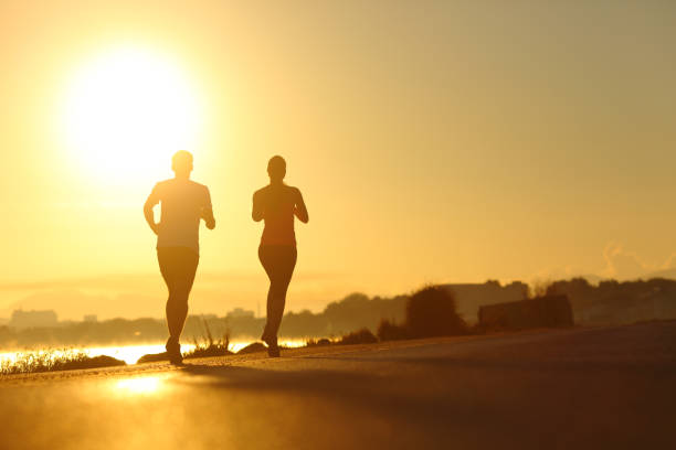 istock Couple practicing sport running at sunset on the road 1091692788