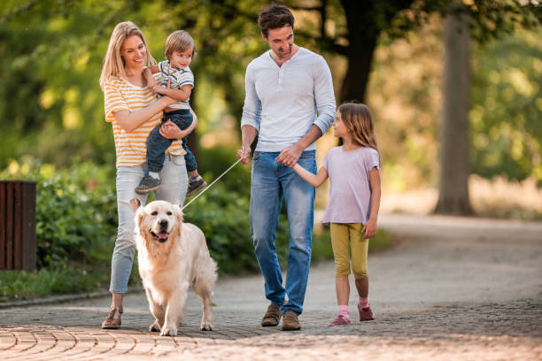 istock Happy family talking while walking with a dog in spring day. 1091692794