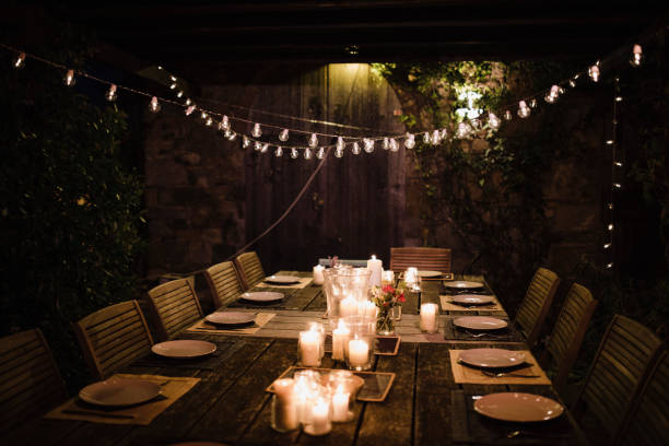 Ready for a Garden Dinner Party Night shot of a dressed garden table illuminated by candles and string lights. garden lights candle stock pictures, royalty-free photos & images