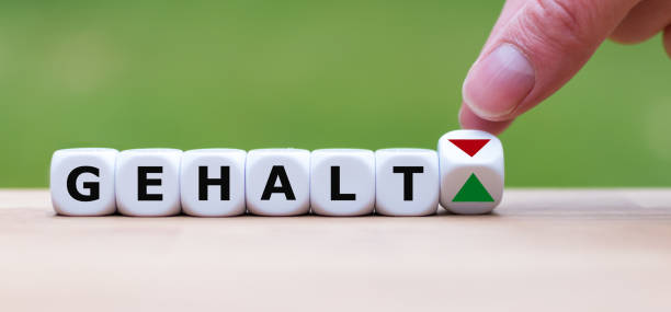 istock Hand is turning a dice and changes the direction of an arrow symbolizing that the personal salary (