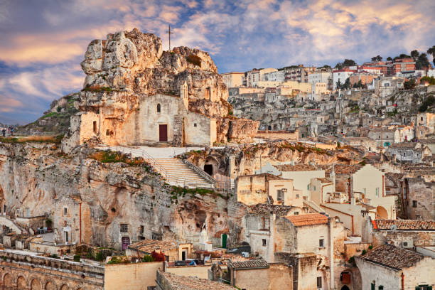 Matera, Basilicata, Italy: landscape of the old town with the rock church Santa Maria de Idris Matera, Basilicata, Italy: landscape at sunset of the old town (sassi di Matera) with the rock church Santa Maria de Idris cliff dwelling stock pictures, royalty-free photos & images