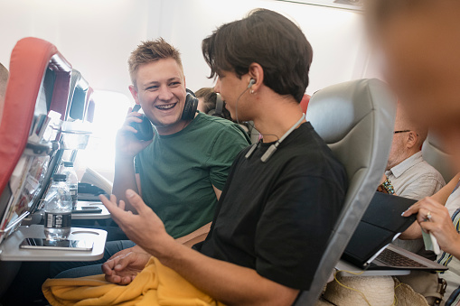 Hombres jóvenes hablando en un vuelo photo