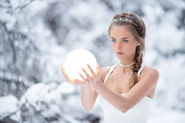 Photo of Magical Snow Princess holding a glowing Ball in her Hands, Frozen Fairy Tale