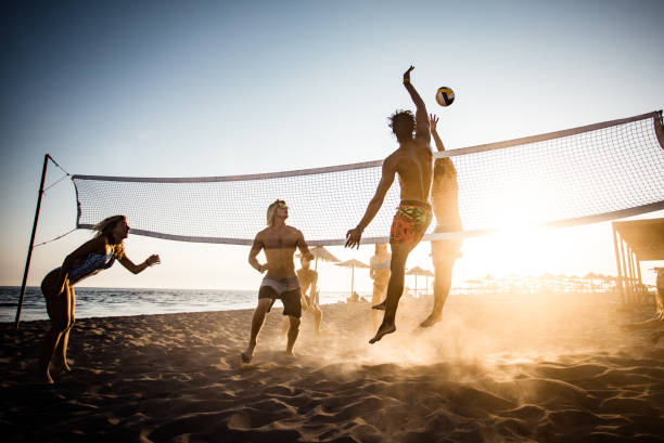 volleyball spielen am strand! - strand volleyball stock-fotos und bilder