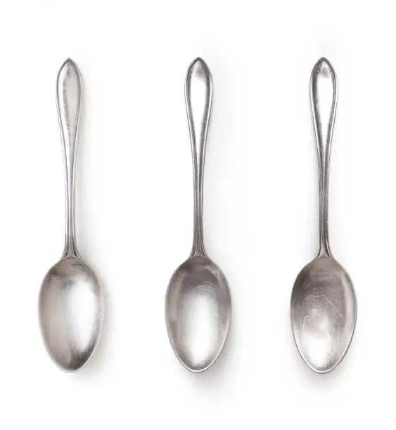 old silver spoon with different light isolated on white background with clipping path included, high angle view