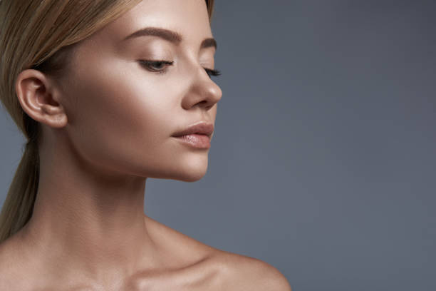 istock Calm woman looking down while standing against the grey background 1091709338
