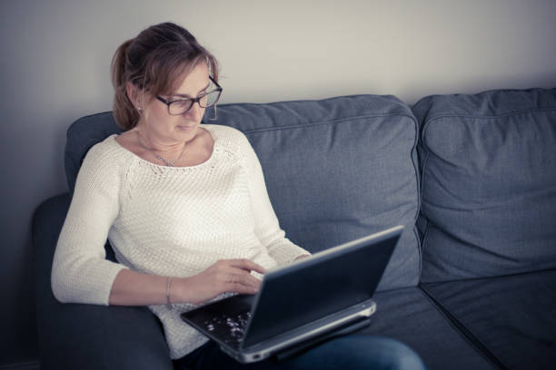 istock Middle-aged woman using laptop at home 1091709772