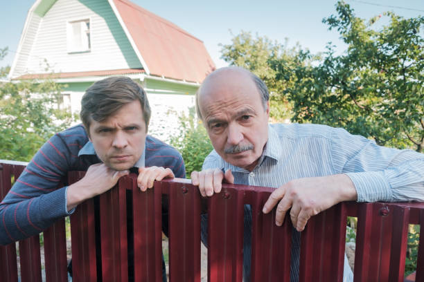 istock two caucasian men carefully watching over the fence. 1091710236