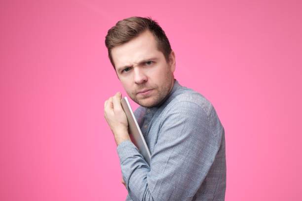 istock Man hiding his tablet from his friend. 1091711096