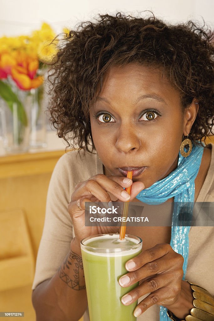 Donna beve un frullato alla frutta - Foto stock royalty-free di Bere