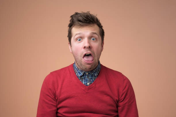 istock Young funny man in white shirt, gesturing shocked or surprised expression with mouth open 1091713058