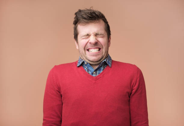 istock Guy grins at camera, shows white teeth, closes eyeswaiting for gift 1091713086