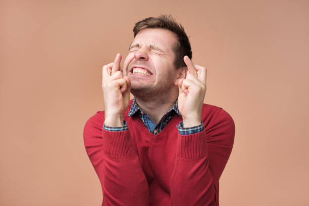 istock Young man making a wish isolated on brown background 1091713474