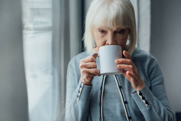 istock sad senior woman drinking coffee at home 1091713924