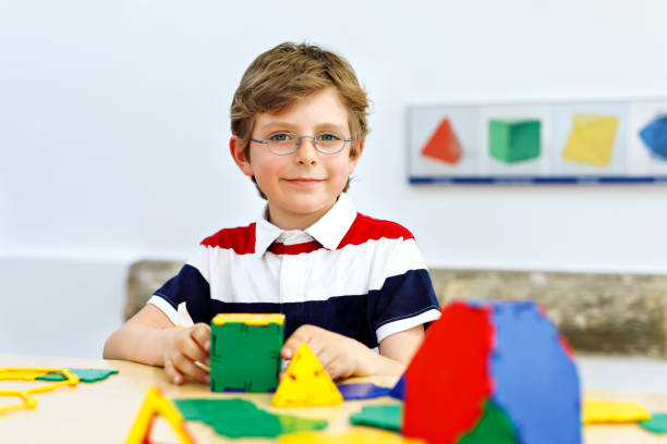istock Happy kid boy with glasses having fun with building and creating geometric figures, learning mathematics and geometry 1091719874