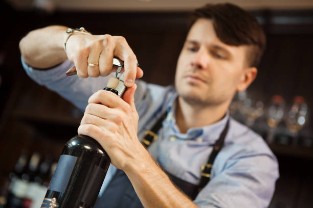 istock Male sommelier open wine bottle with corkscrew. 1091720714