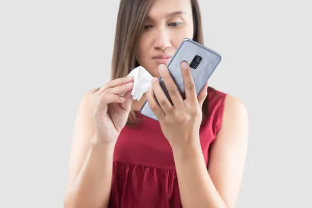 Photo of Cleaning her mobile phone.