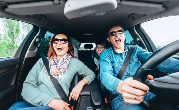 Singing family in car Cheerful young traditional family has a long auto journey and singing aloud the favorite song together. Safety riding car concept wide angle inside car view image. teenager boy driving stock pictures, royalty-free photos & images