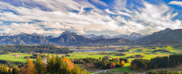 panoramic view to beautiful landscape in Bavaria with lake and mountains panoramic view to beautiful landscape in Bavaria with lake and mountains forggensee lake photos stock pictures, royalty-free photos & images