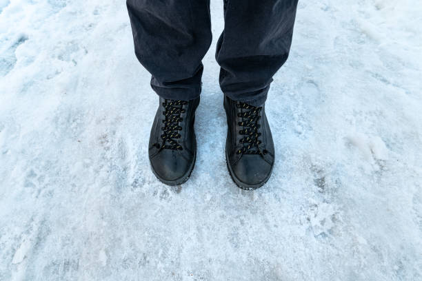 istock Male feet in boots standing in snow 1091733260