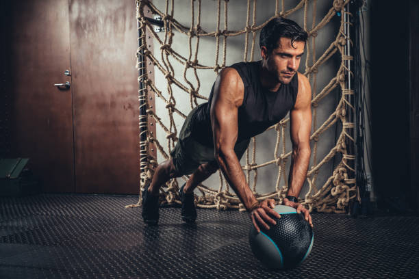 kuvapankkikuvat ja rojaltivapaat kuvat aiheesta urheilijan harjoitukset lankku poseeraa lääkepallossa - medicine ball