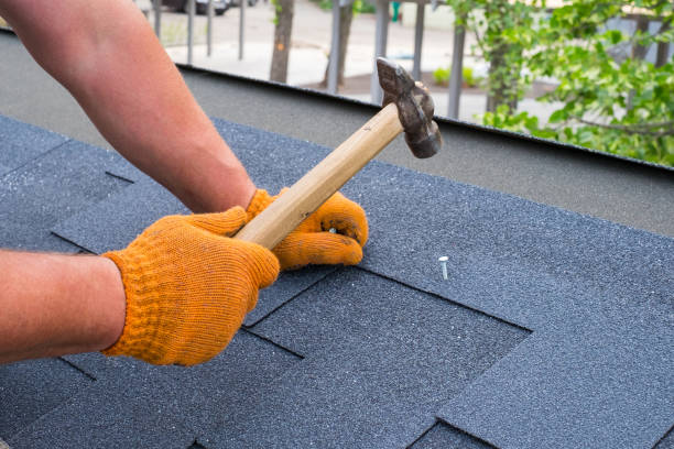 istock Workers hands installing bitumen roof shingles using hammer in nails. 1091733968