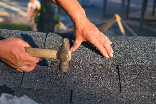 istock Workers hands installing bitumen roof shingles using hammer in nails. 1091734000