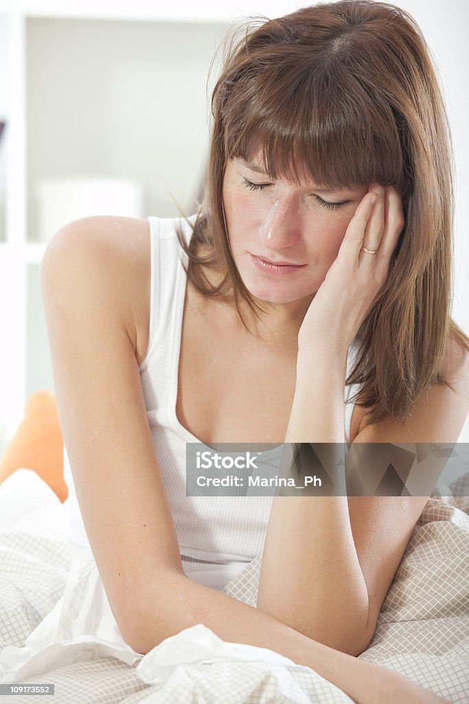 Frau mit Kopfschmerzen auf Bett - Lizenzfrei Besorgt Stock-Foto