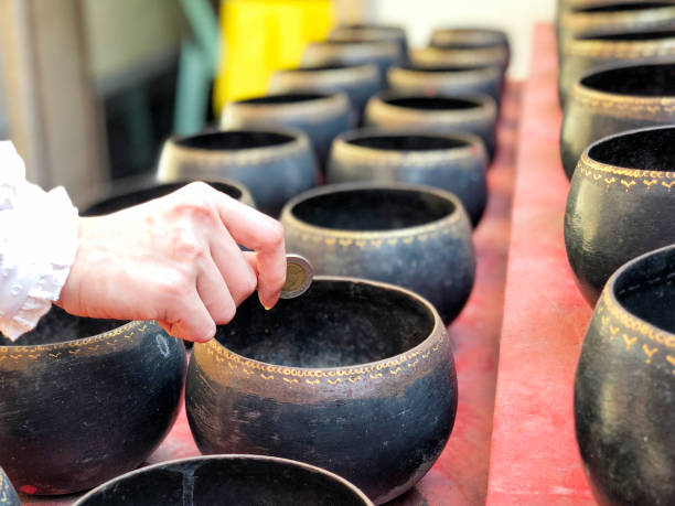 istock Woman donating money into Buddhist monk's alms bowl for making merit 1091742886