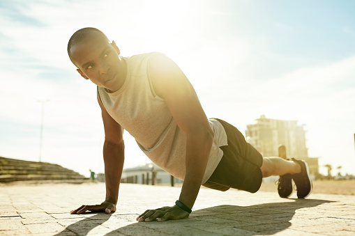 Shot of a handsome young man doing his exercise routine outside