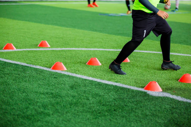 istock Soccer player Jogging and jump between cone markers on green artificial turf for soccer training 1091749744