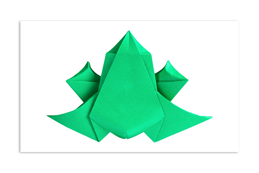 Bright green frog out of paper. Origami. The concept of minimalism.
