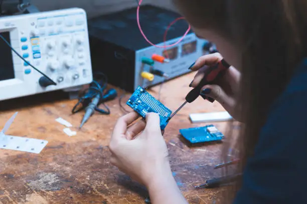 STEM, Student, Circuits - Young female STEM student working on a circuit board for her class project in the lab.