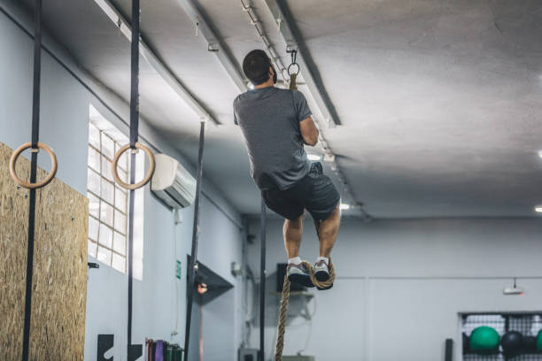 istock Young man climbing rope at the gym 1091752502