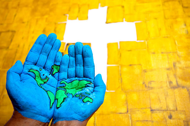 World Map painted on hands in front of Cross sign