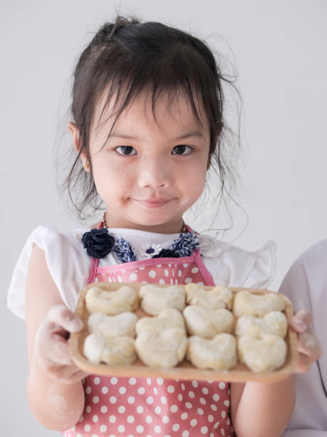 Girl showing her homemade bread or donut, lifestyle concept.