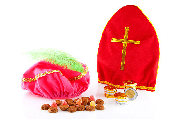 Mitre from sinterklaas and hat of zwarte piet Mitre from sinterklaas and hat of zwarte piet ( black pete) with dutch candy over white background zwarte piet stock pictures, royalty-free photos & images