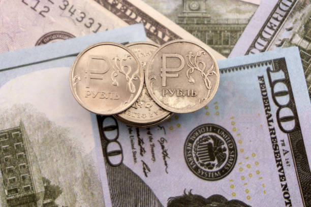 istock coin one ruble against the background US dollars background . 1091763956